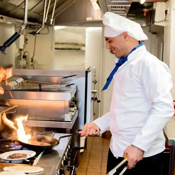 [[community_name]] chef cooking meal in kitchen