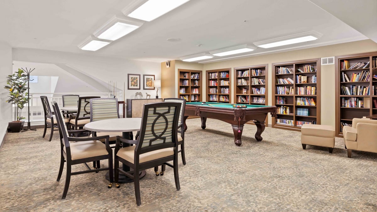 The library at Carolina Estates with shelves of books and comfortable seating